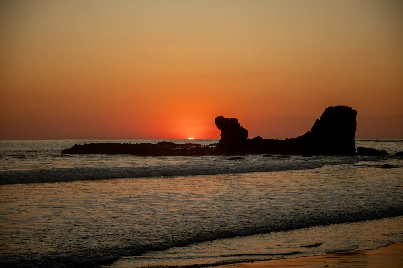 La formación rocosa frente a la playa de El Tunco, en silueta al atardecer