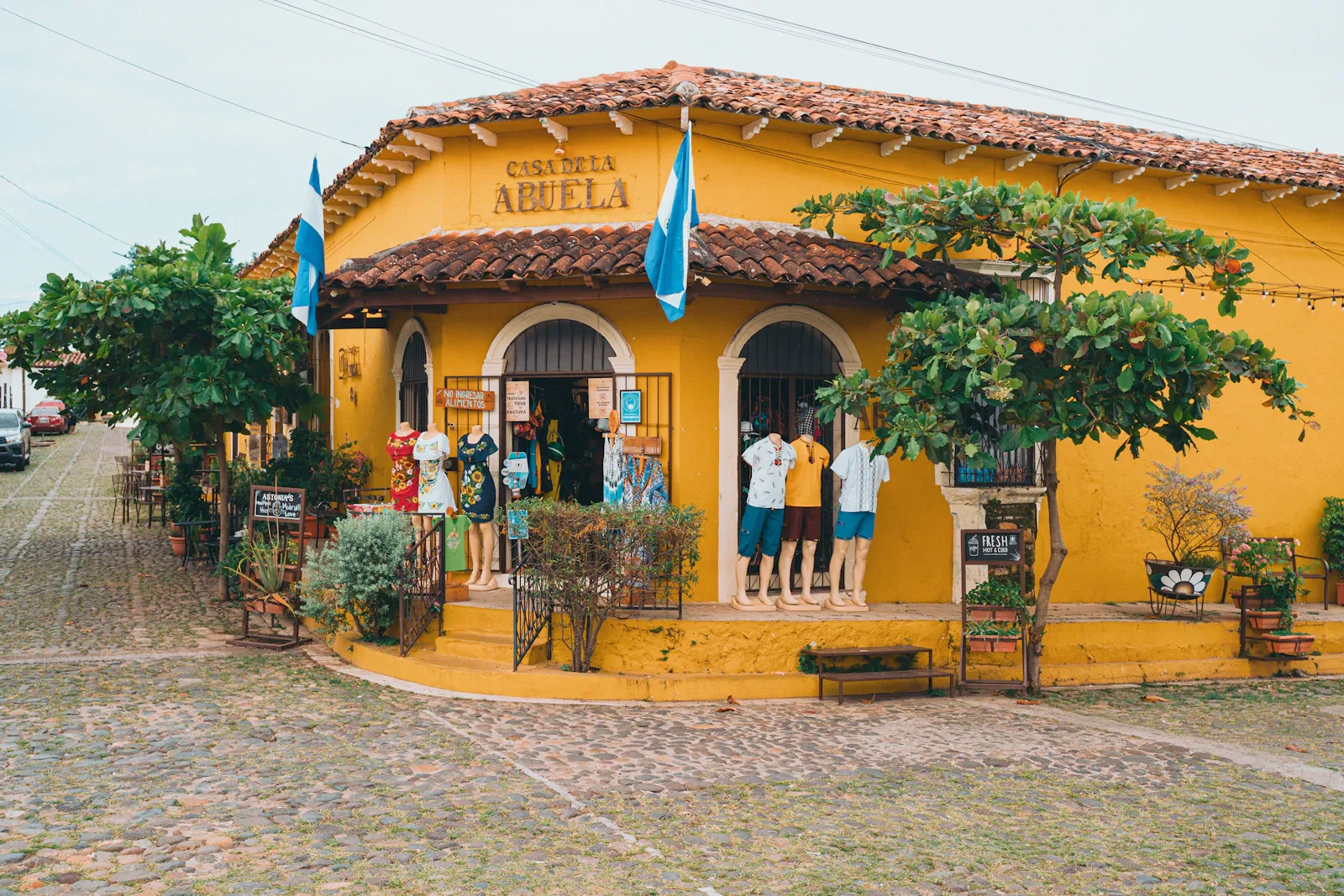 Un edificio pintado de amarillo en una calle de uno de los pueblos de la Ruta de las Flores