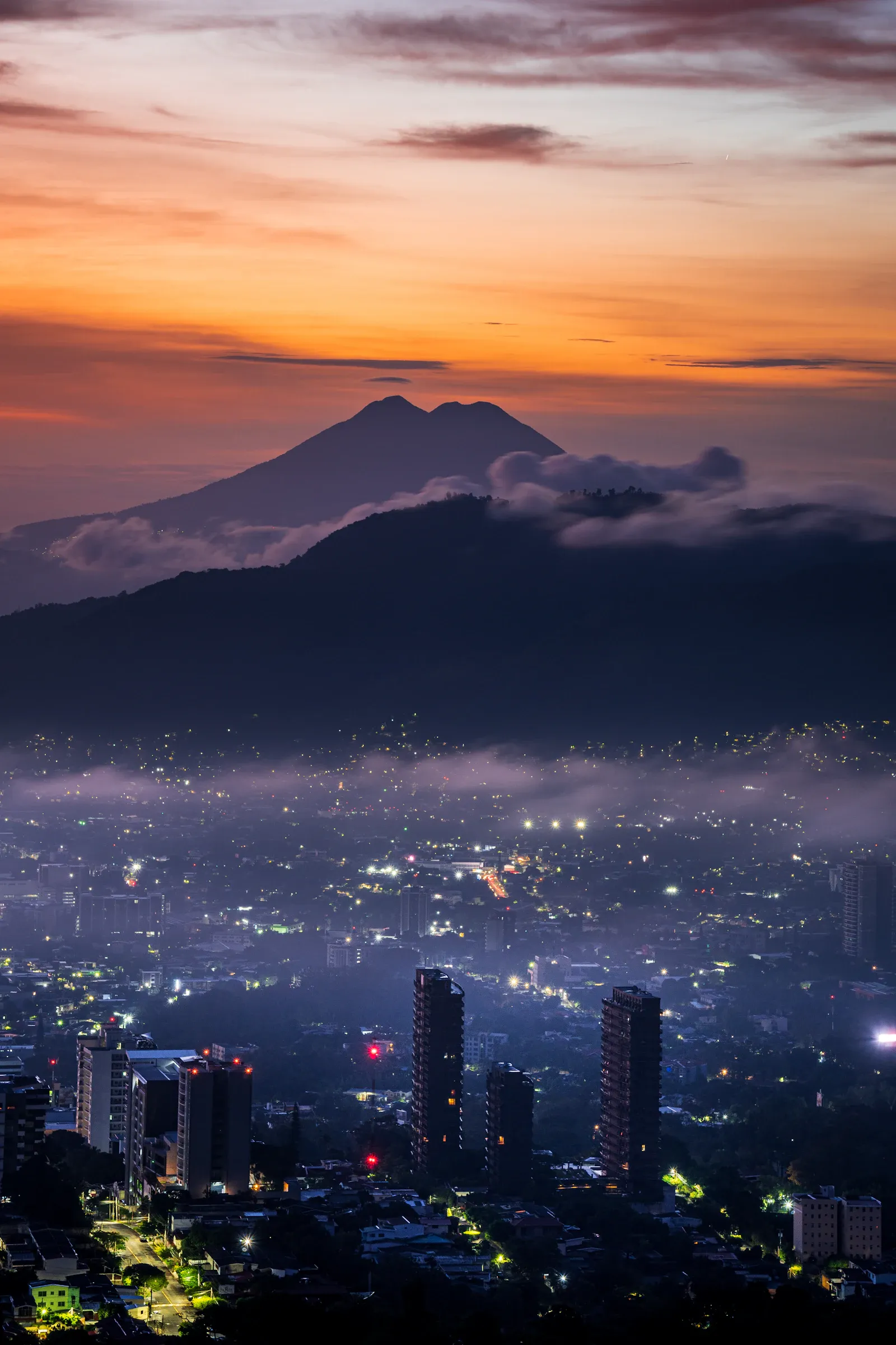 Techos de San Salvador con el volcán elevándose detrás de la ciudad