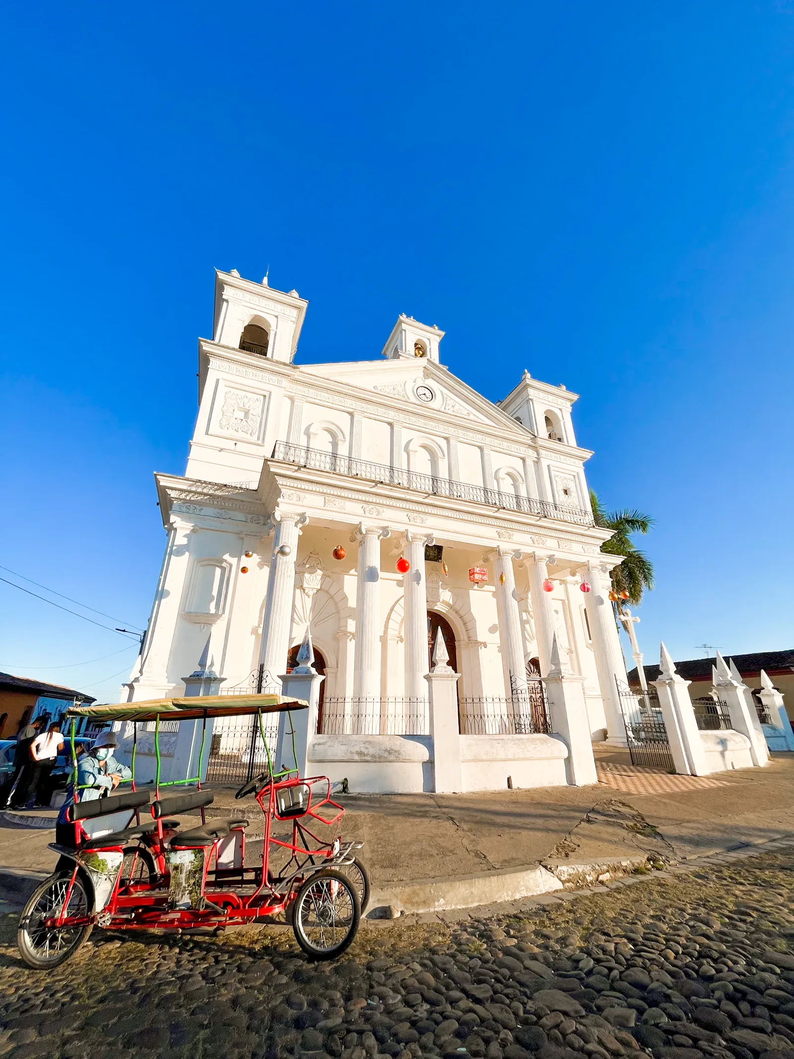 Un edificio colonial blanco en una calle de Suchitoto